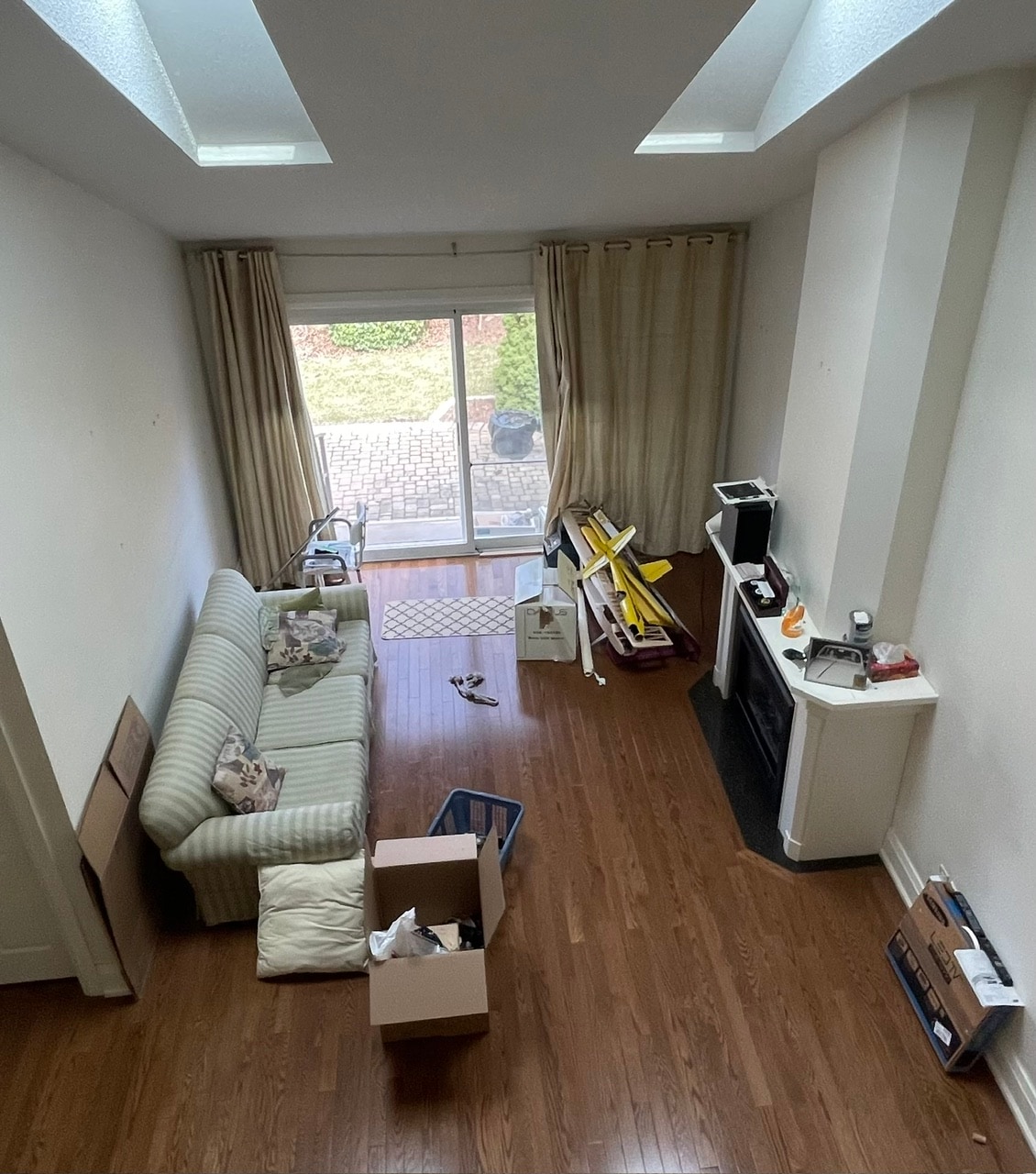 Empty living room with skylights before staging, moving boxes visible